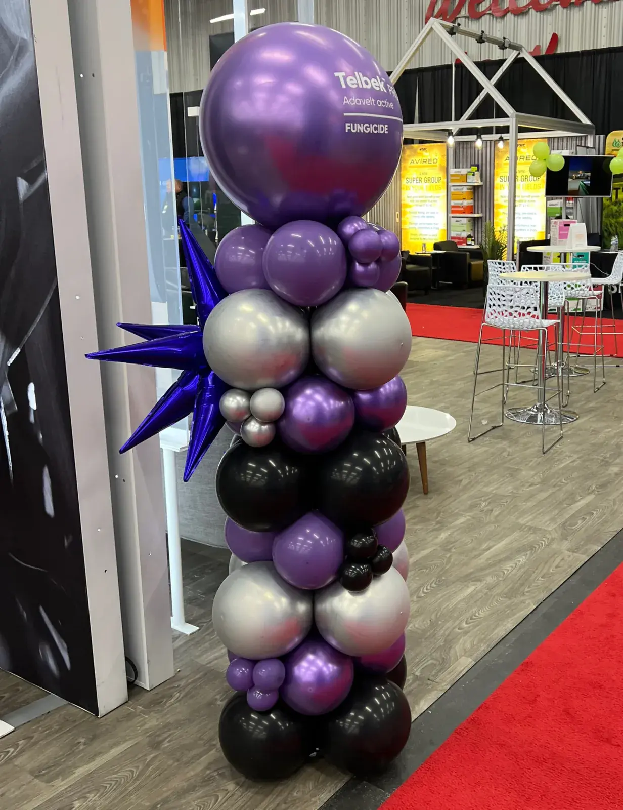 Purple, silver and black balloon column on a trade show floor