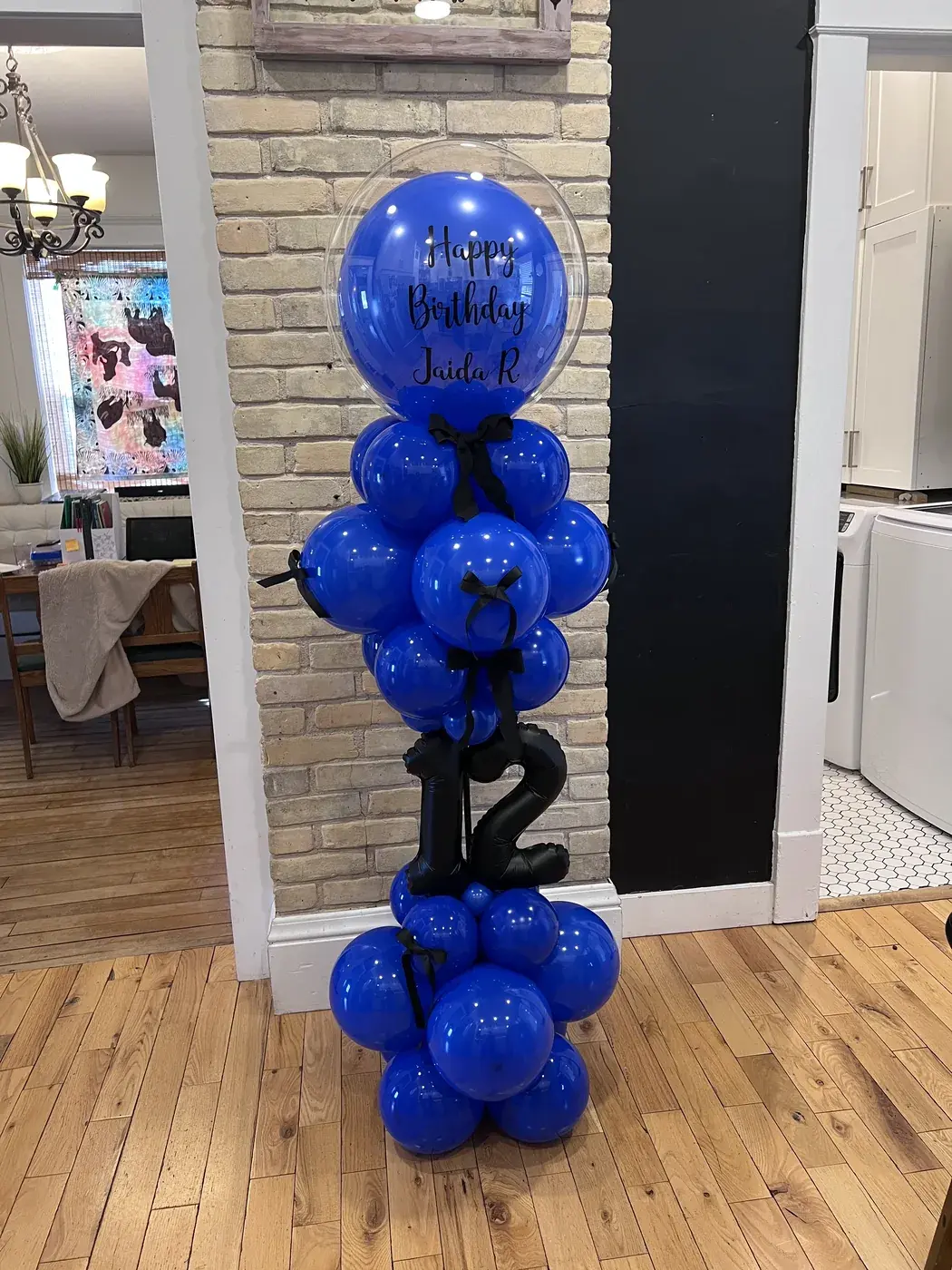 Royal blue balloon column with a black number twelve and a personalised orb