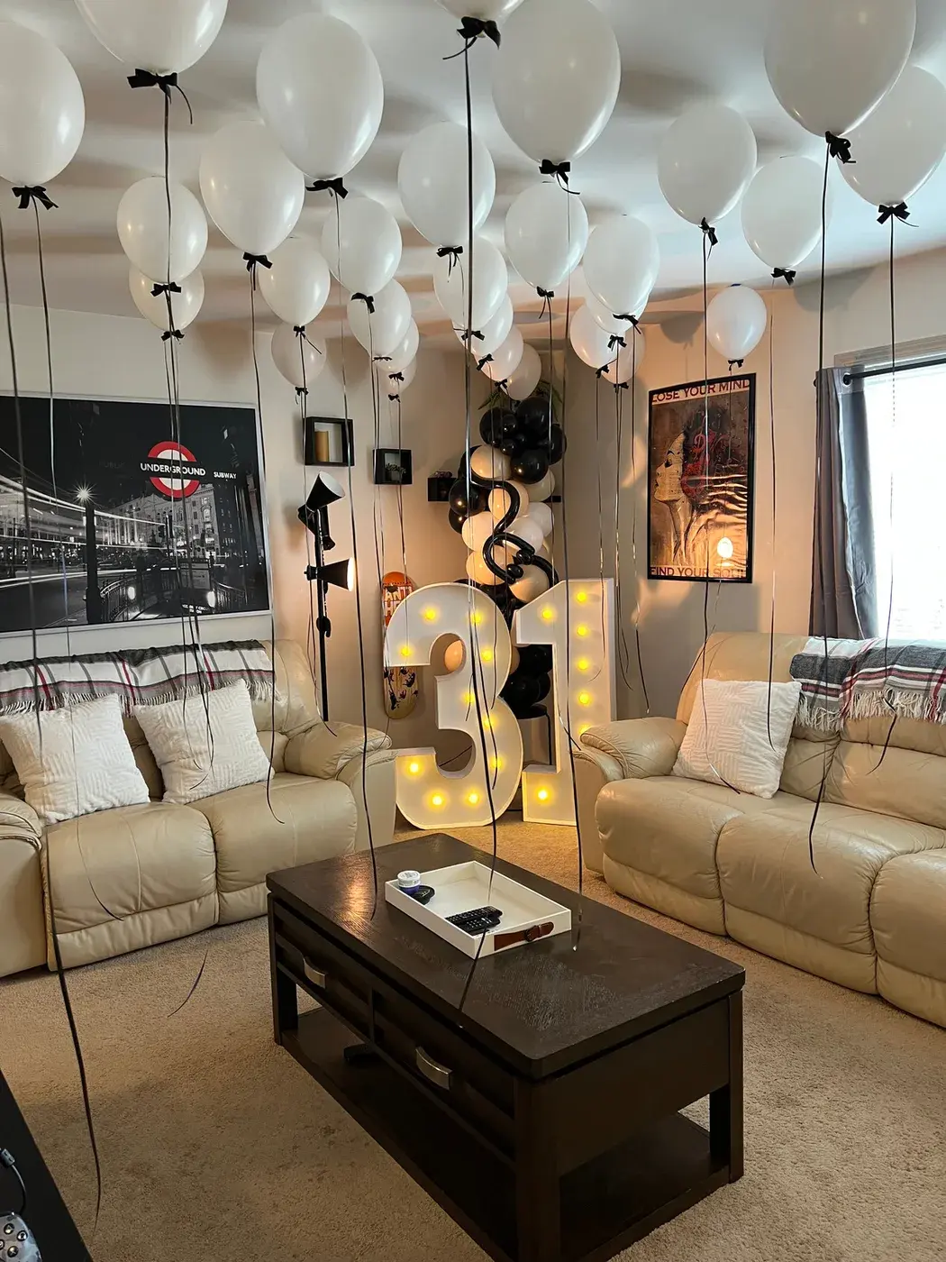 Gold 31 marquee numbers under a ceiling filled with black and white balloons